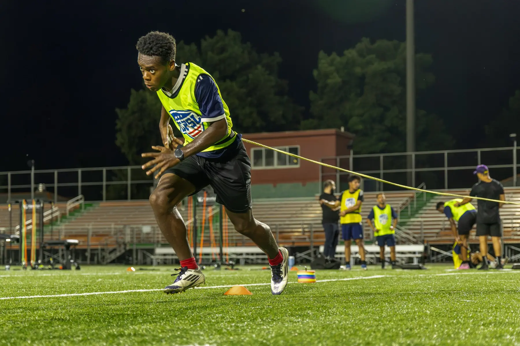 Semi-professional soccer player completing a resisted acceleration drill with VigourGym